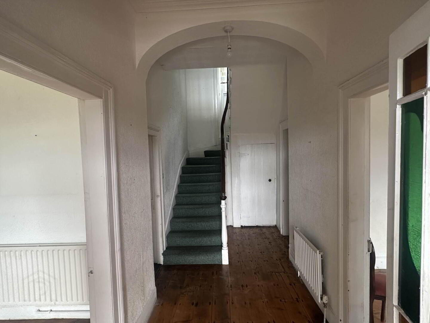 Central hallway with arched ceiling and original staircase