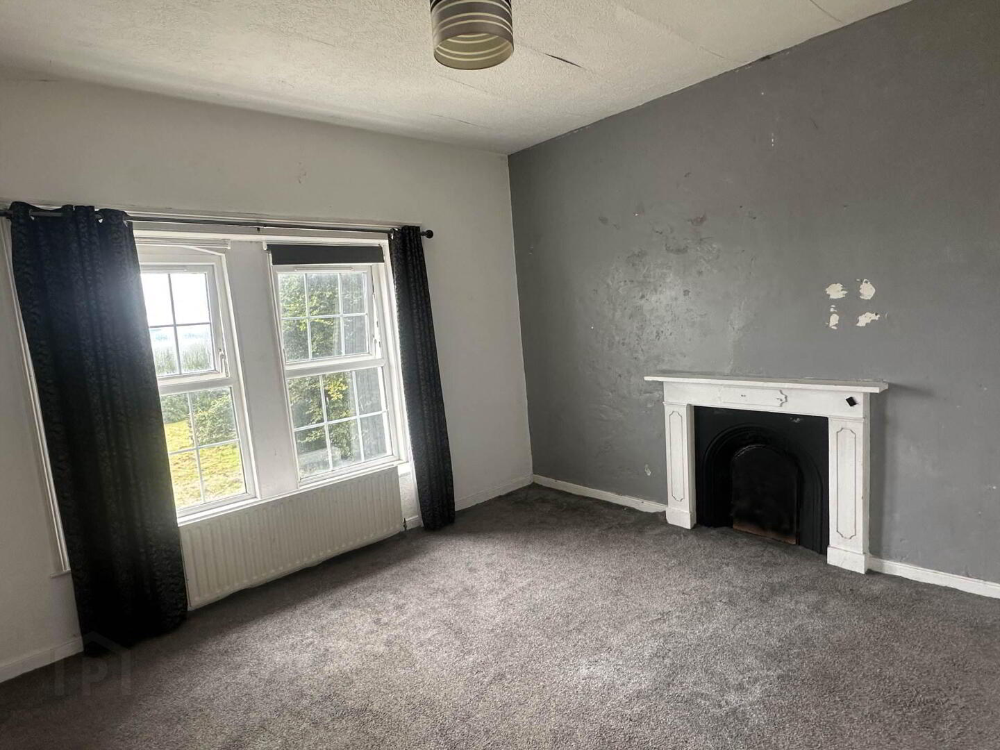 Front-facing bedroom with cast-iron fireplace
